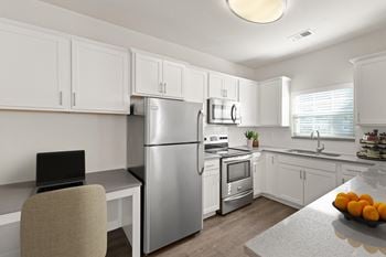 A kitchen with white cabinetry and stainless steel appliances